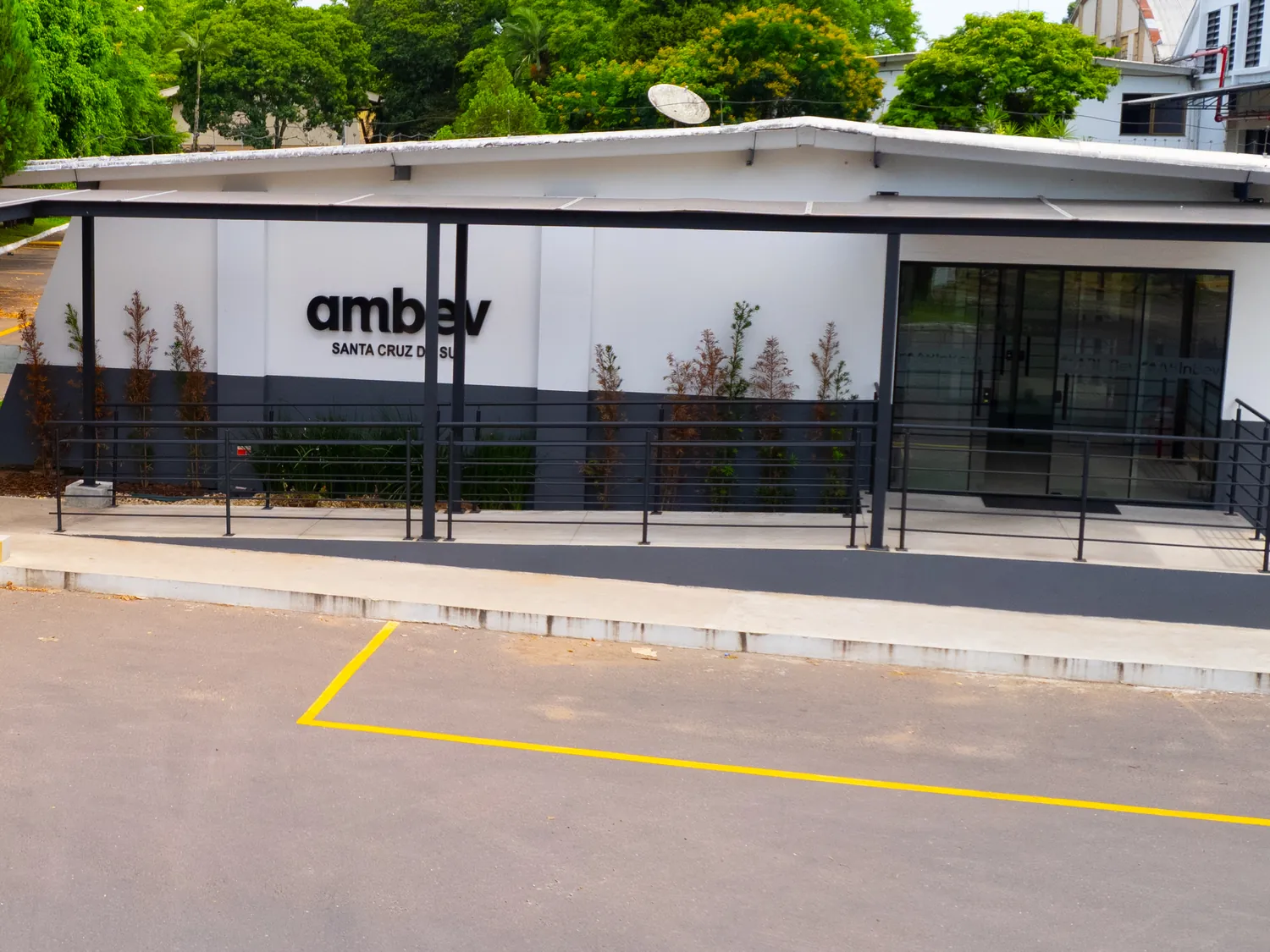 Fachada e acesso coberto do prédio administrativo da Ambev em Santa Cruz do Sul, entregue pela Ápice.